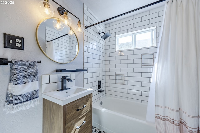 full bath with a textured wall, shower / bath combination with curtain, and vanity