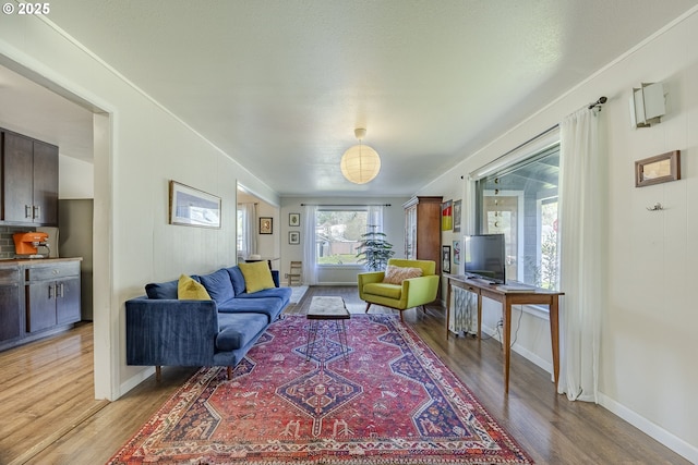 living area featuring light wood-style floors and baseboards