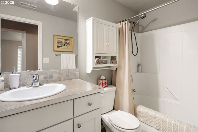 bathroom featuring toilet, visible vents, shower / bathtub combination with curtain, and vanity
