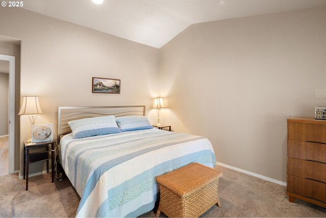 carpeted bedroom with baseboards and vaulted ceiling