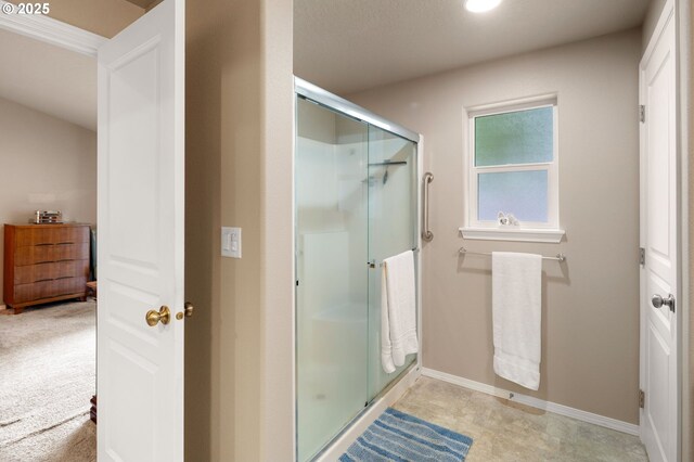 full bathroom featuring baseboards and a shower stall
