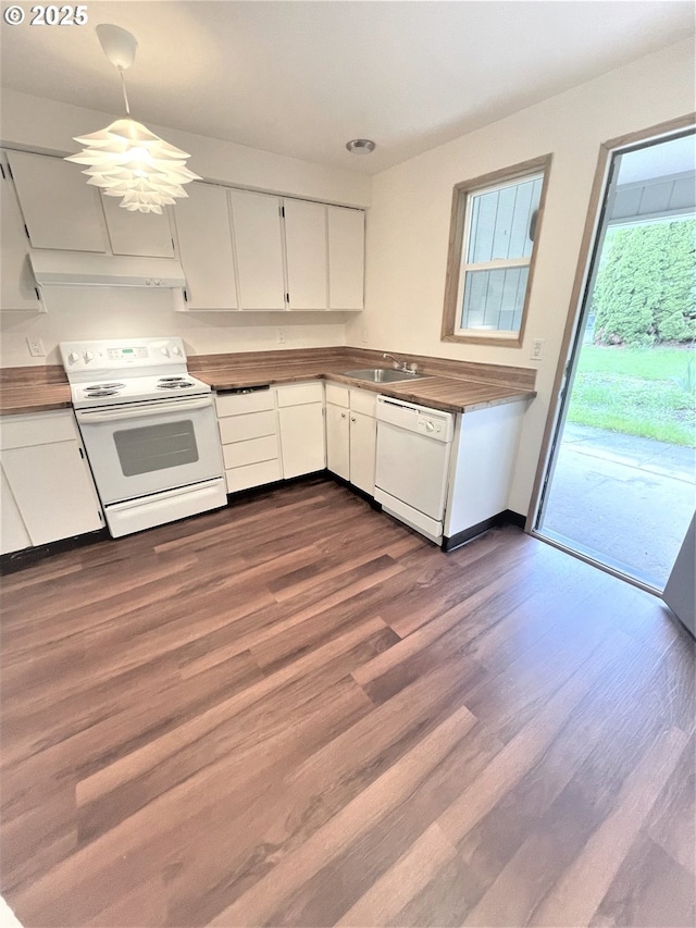 kitchen with dark countertops, dark wood-style flooring, white cabinetry, and white appliances