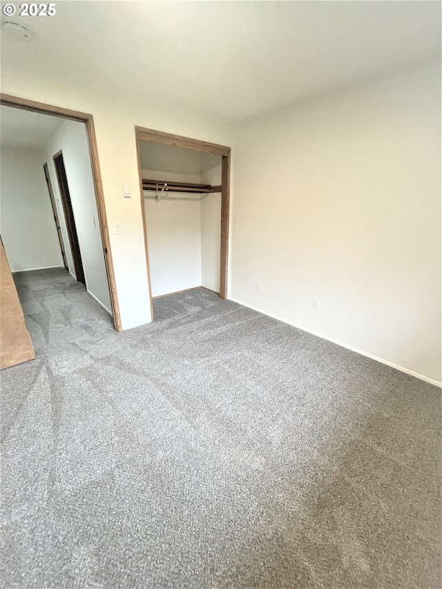 unfurnished bedroom featuring carpet floors and a closet