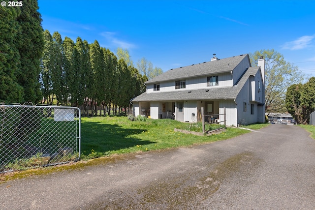 exterior space featuring fence, a chimney, roof with shingles, and a front yard