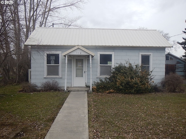 bungalow-style house featuring metal roof and a front lawn