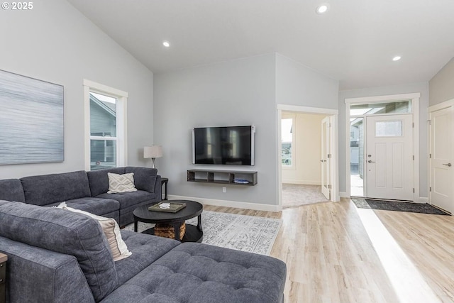 living area with healthy amount of natural light, light wood-style floors, recessed lighting, and baseboards