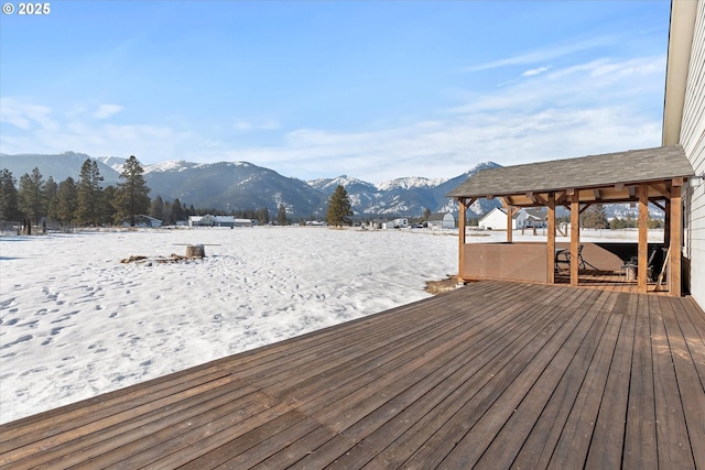 snow covered deck with a mountain view