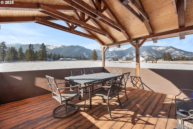 snow covered deck with a mountain view