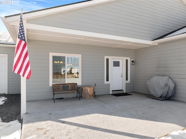 view of exterior entry with a patio area