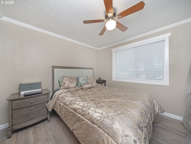 bedroom with ceiling fan, ornamental molding, light hardwood / wood-style flooring, and a textured ceiling