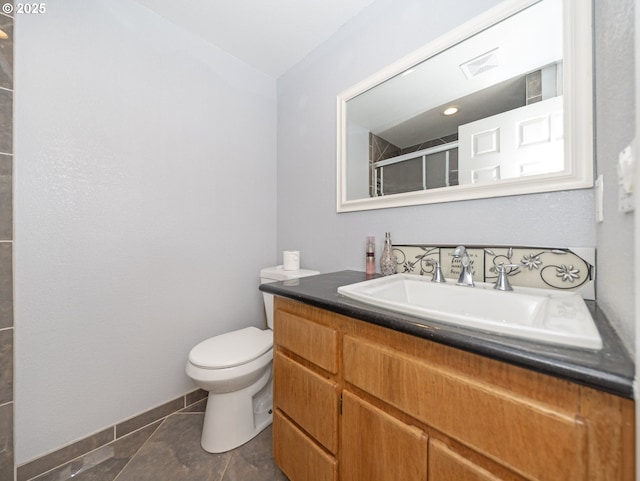 bathroom with vanity, a shower with shower door, tile patterned floors, and toilet