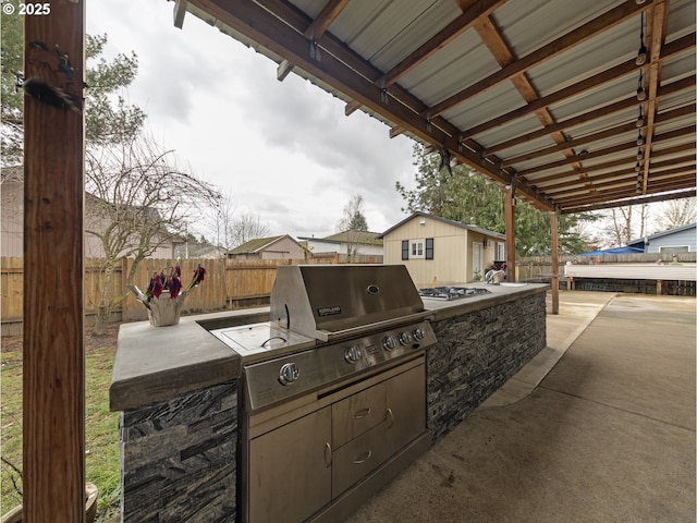 view of patio / terrace with an outbuilding, area for grilling, and exterior kitchen