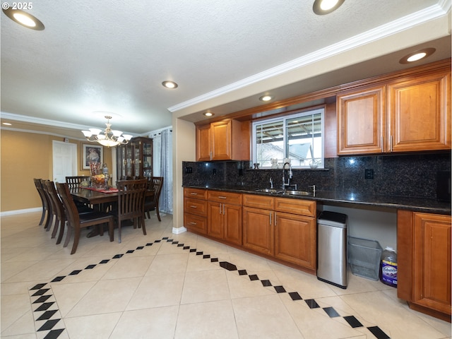 kitchen featuring tasteful backsplash, light tile patterned floors, ornamental molding, and dark stone counters