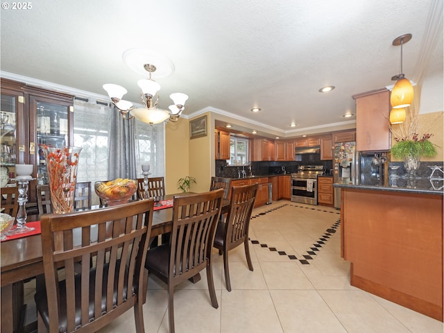 dining room with an inviting chandelier, light tile patterned floors, crown molding, and sink