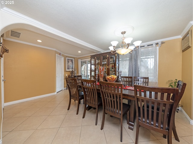 dining space with ornamental molding, a chandelier, and light tile patterned floors