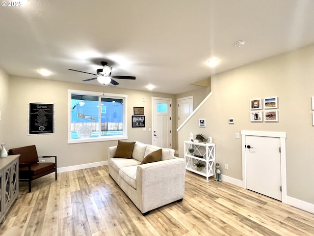 living room featuring ceiling fan and light hardwood / wood-style flooring