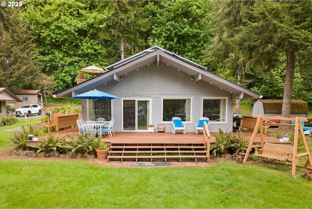 back of house with a deck and a yard