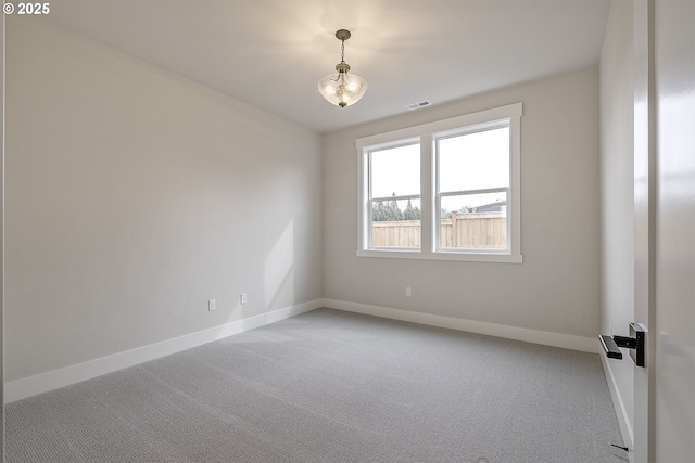 spare room featuring baseboards, visible vents, an inviting chandelier, and light colored carpet