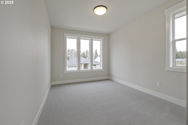 carpeted spare room featuring baseboards