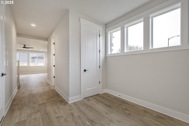 corridor with recessed lighting, baseboards, and wood finished floors