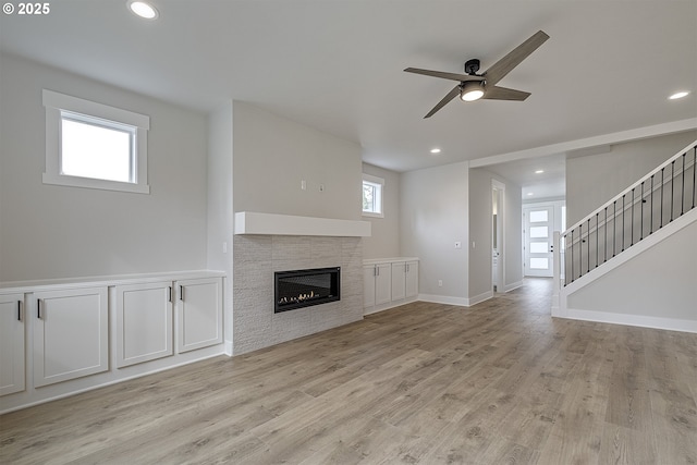 unfurnished living room featuring a fireplace, ceiling fan, light wood-style flooring, and recessed lighting