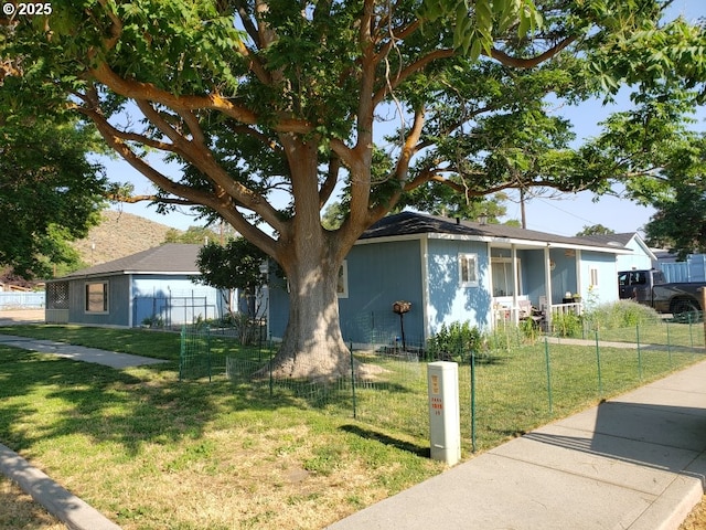 ranch-style home with a front lawn and a fenced front yard