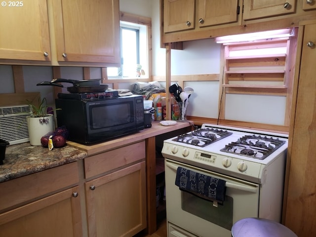 kitchen featuring white gas stove and black microwave
