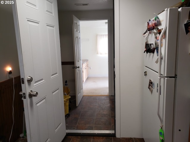 hall with stone finish floor and visible vents