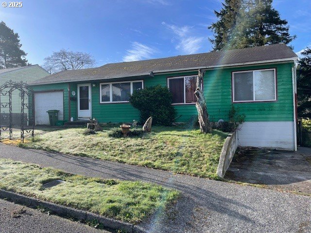 single story home featuring a front yard and an attached garage