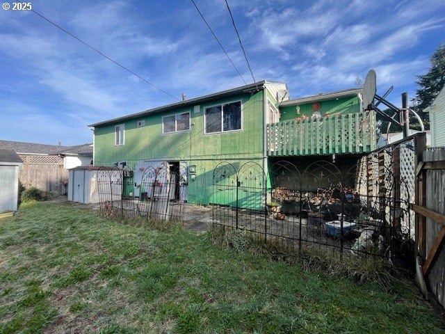 back of house with a lawn and fence