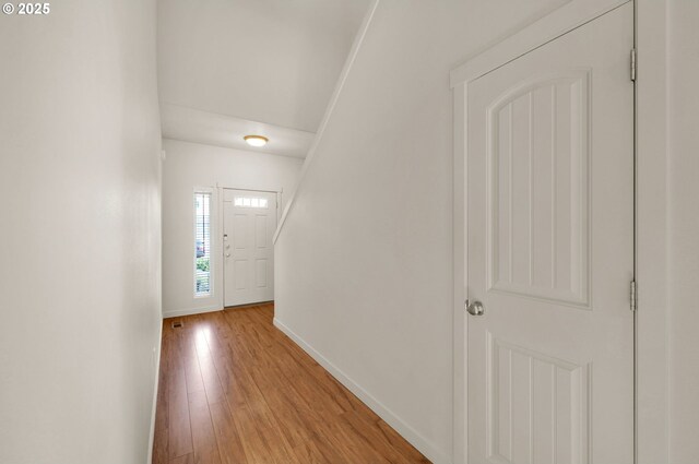 foyer entrance with baseboards and light wood finished floors