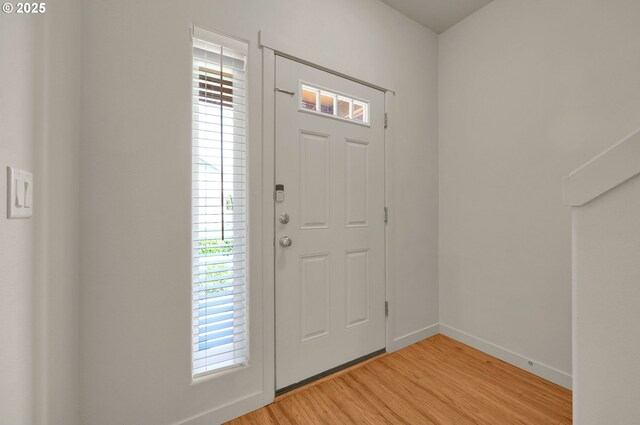 entrance foyer with baseboards and light wood-style floors
