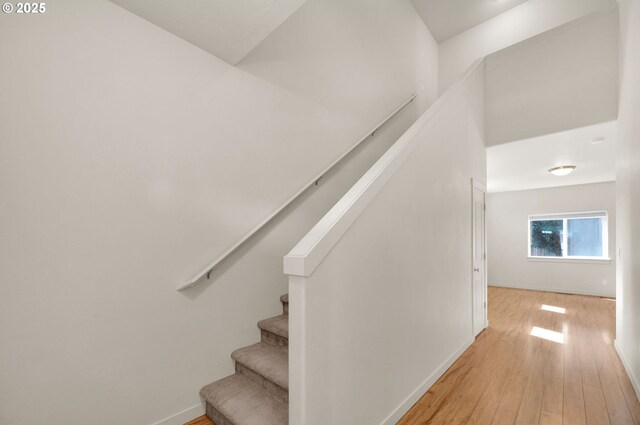 stairway featuring baseboards and hardwood / wood-style floors