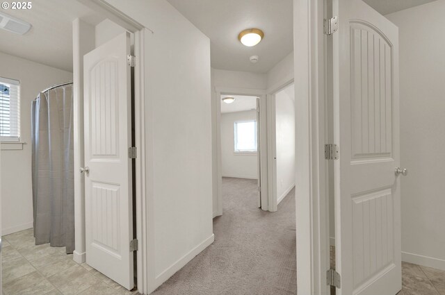 corridor with baseboards and visible vents
