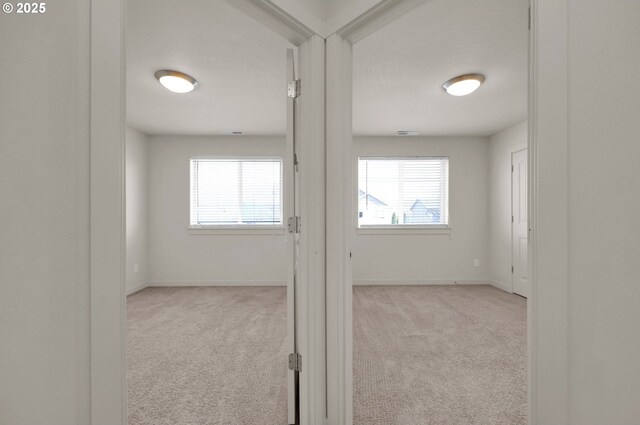 hall with baseboards and carpet