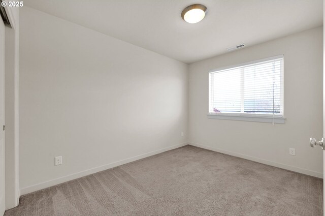 carpeted spare room with baseboards and visible vents