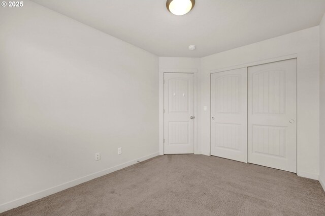 unfurnished bedroom featuring carpet flooring, a closet, and baseboards