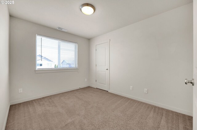 carpeted empty room featuring baseboards and visible vents
