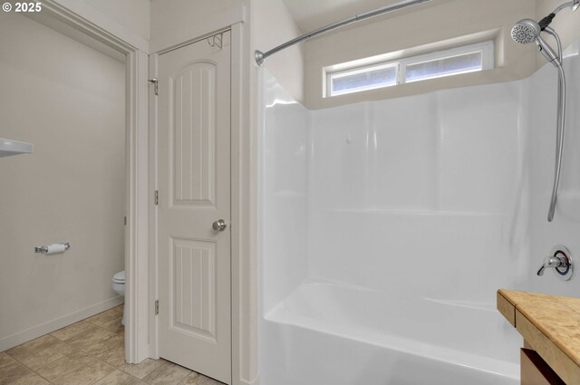 full bath featuring toilet, vanity, tile patterned flooring, tub / shower combination, and baseboards