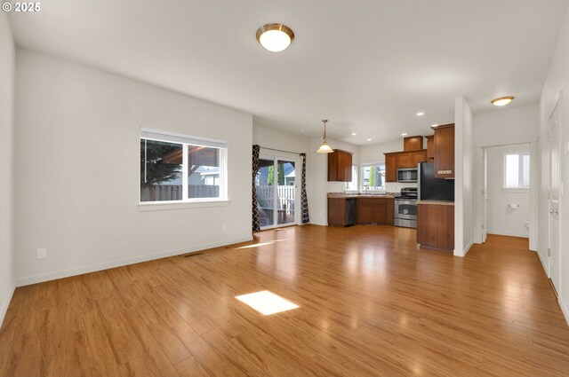 unfurnished living room with light wood-style flooring, baseboards, and recessed lighting