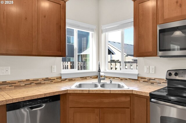 kitchen with brown cabinets, stainless steel appliances, and a sink