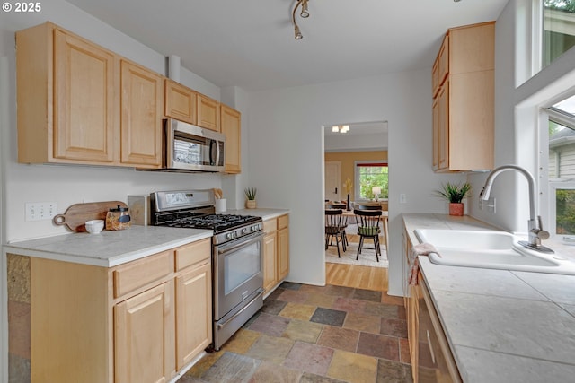 2951 NE 35th Ave, Portland, OR 97212 - kitchen with stainless steel appliances, light brown cabinets, stone finish floors, and tile counters