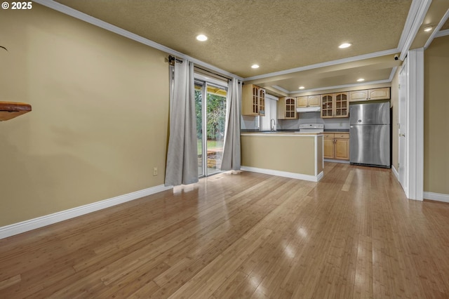 kitchen featuring glass insert cabinets, under cabinet range hood, ornamental molding, light wood-style flooring, and freestanding refrigerator