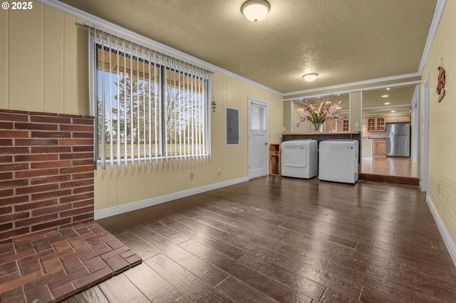 interior space with hardwood / wood-style floors, electric panel, a textured ceiling, washer and dryer, and crown molding