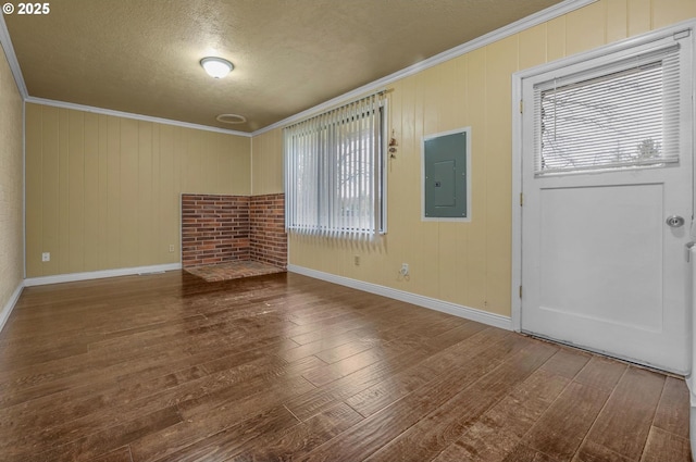 interior space with electric panel, crown molding, and wood finished floors