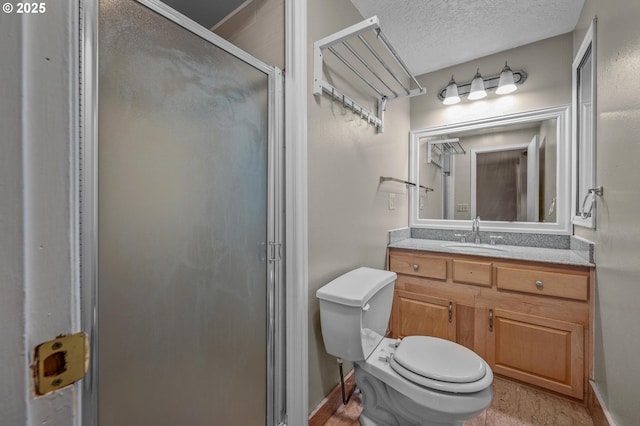 bathroom featuring a shower stall, a textured ceiling, vanity, and toilet