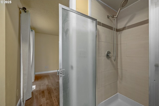 bathroom featuring wood finished floors and a stall shower