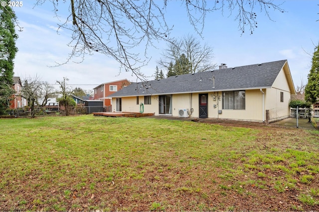 rear view of house featuring a lawn, a fenced backyard, and a chimney