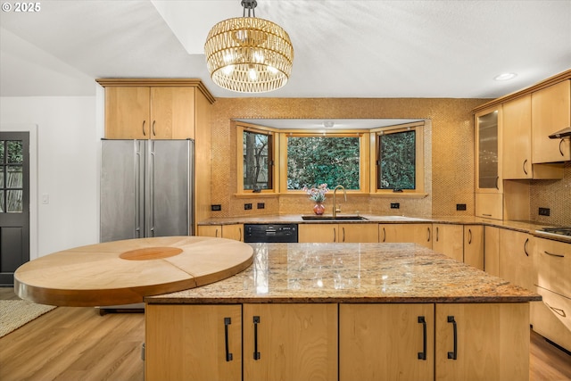 kitchen with hanging light fixtures, high end refrigerator, a kitchen island, and sink