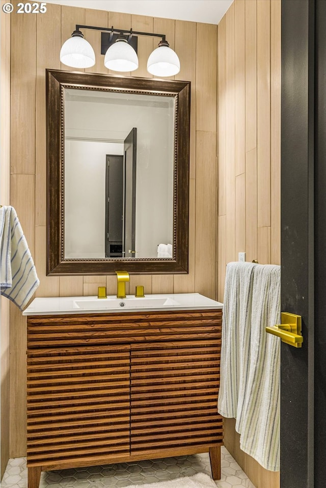 bathroom with vanity and wood walls